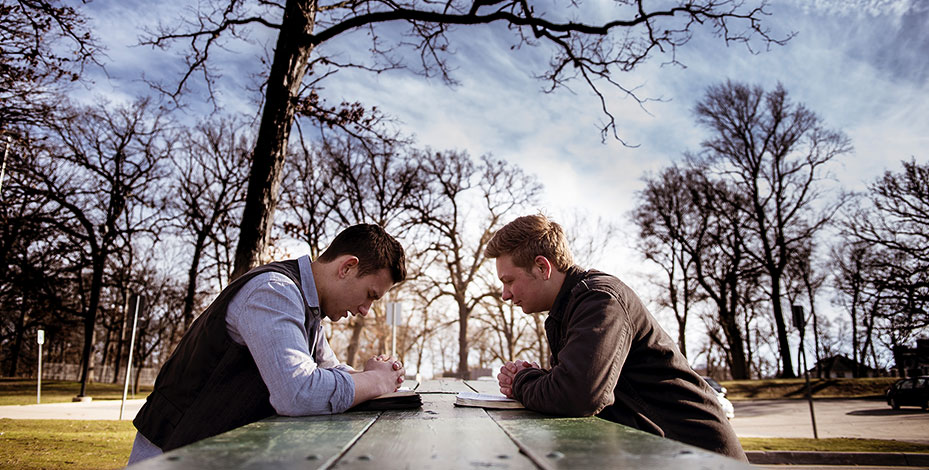 Deux hommes qui prient sur une table à l'extérieur